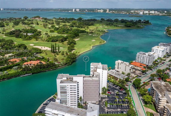 Aerial view of buildings near a body of water and a golf course.