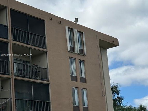 Front view of a multi-story apartment building with balconies.