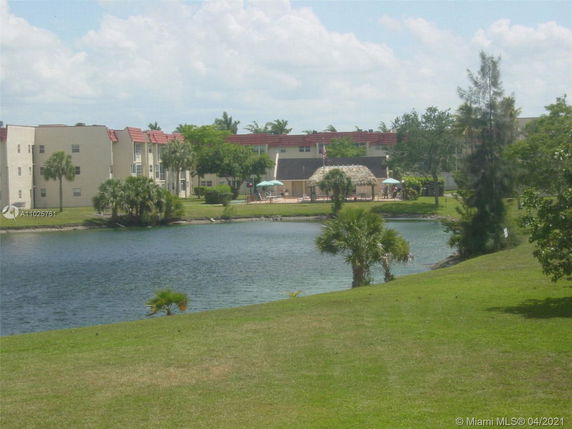 View of a residential complex with buildings and a water body.