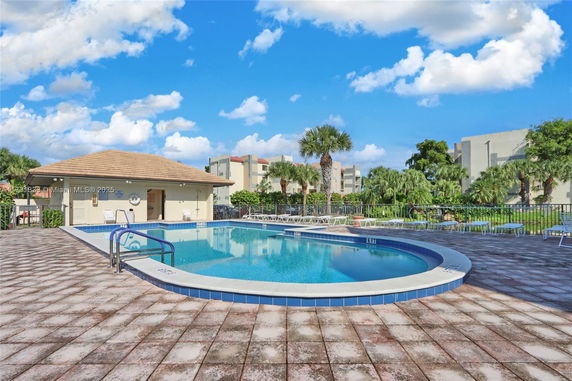 Outdoor swimming pool area with a small building nearby.