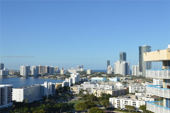 Panoramic view of a cityscape with high-rise buildings and a body of water in the background.