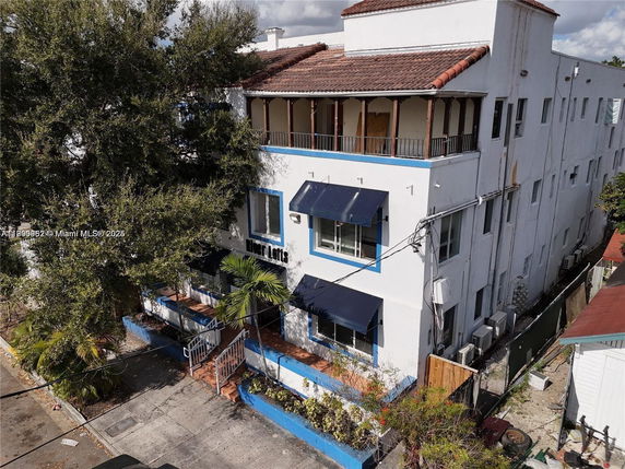 Front view of a multi-story building with awnings and a balcony.