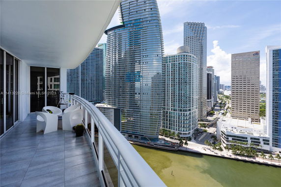 Panoramic view from a balcony overlooking a cityscape with tall buildings.