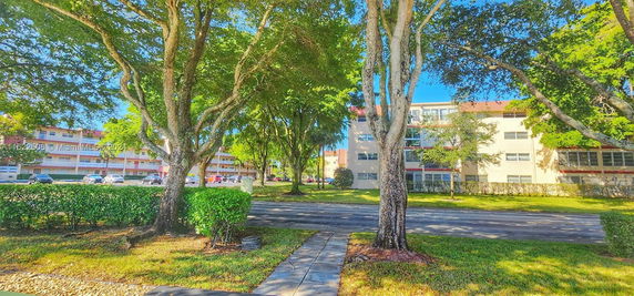 Residential buildings and parking area with trees and greenery