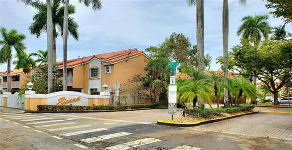 Front view of a multi-story residential building with a terracotta roof.