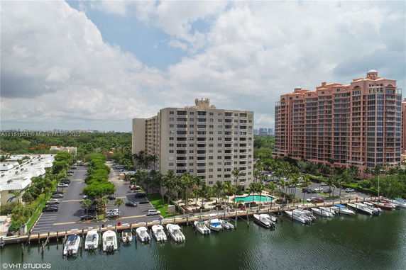 Aerial view of waterfront high-rise buildings with boats docked nearby.