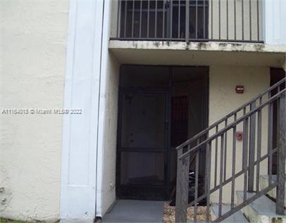 Front view of a multi-story building with a balcony and staircase.