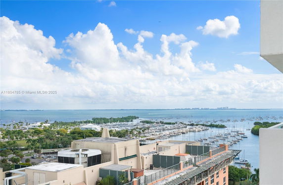 Panoramic view of a marina with numerous boats docked and a distant horizon over the sea.