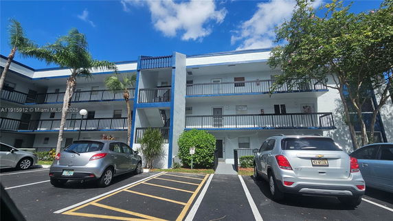Front view of a multi-story residential building with blue accents and balconies.