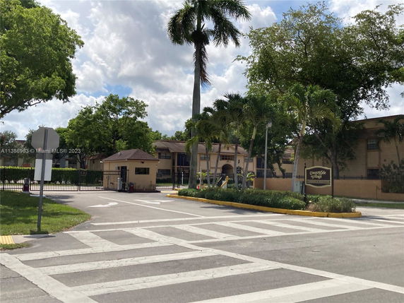 Front view of a residential complex with a gated entry and guard post.