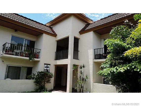Front view of a two-story building with balconies and a pitched roof.