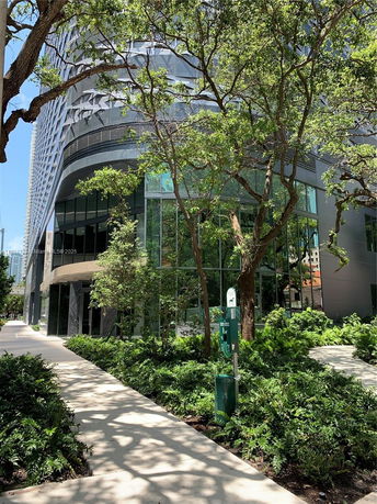 Front view of a modern multi-story building with glass windows and an angular design.