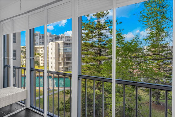 View from a balcony overlooking nearby buildings and greenery.