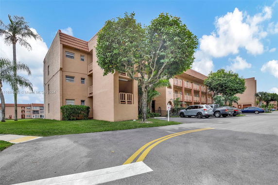 Front view of a multi-story apartment building with balconies.