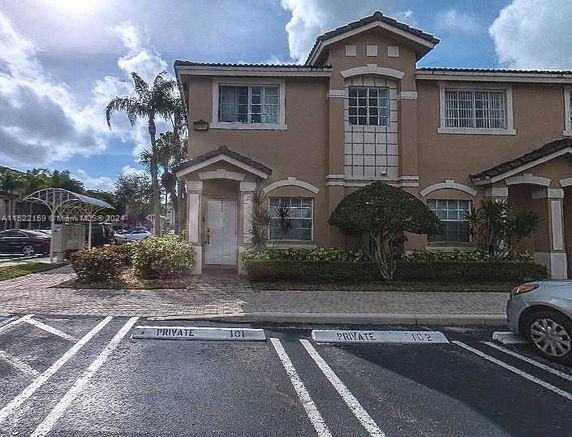 Front view of a two-story townhouse with beige exterior and white trim.