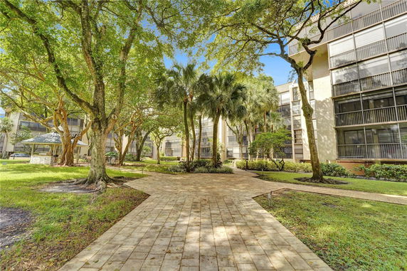 View of landscaped area with trees near residential buildings.
