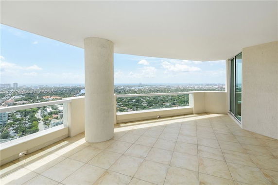Panoramic view from a high-rise balcony with glass railing.