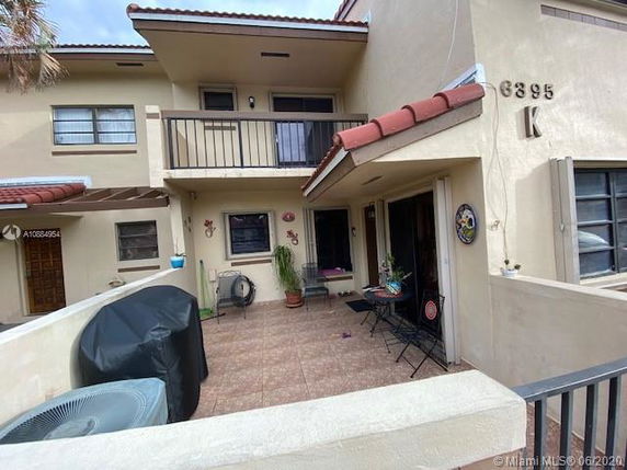 Front view of a two-story residential building with a small patio.