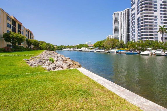 Waterfront view with high-rise buildings and boats.