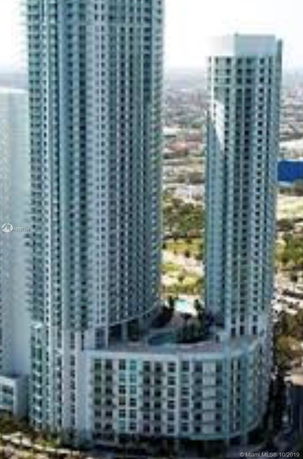 Tall modern building with two connected towers and multiple windows.