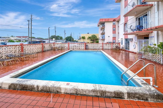 Outdoor swimming pool adjacent to a multi-story building.