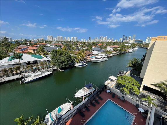 Panoramic view of a canal with boats and distant high-rise buildings.