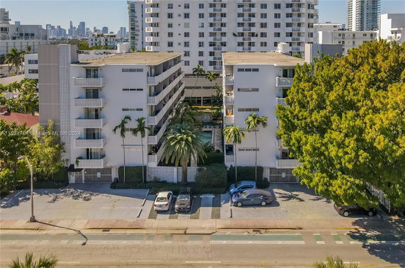 Front view of mid-rise apartment buildings with balconies and a central courtyard area.