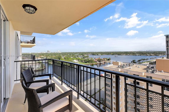 Balcony view overlooking a cityscape with water and buildings.