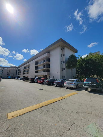 Front view of a multi-story building with a parking lot.