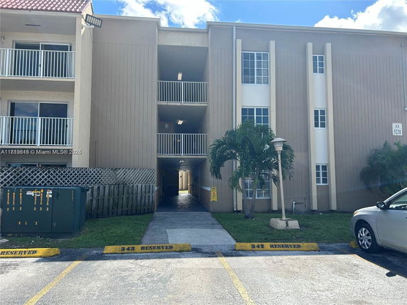 Front view of a multi-story apartment building with balconies.