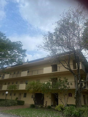 Front view of a multi-story building with balconies on each level.