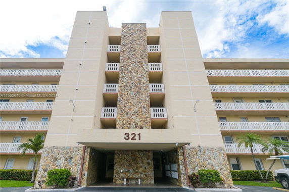 Front view of a multi-story building with stone façade and balconies.