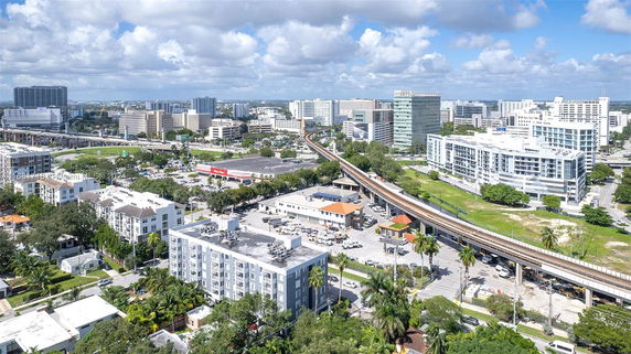 Aerial view of urban buildings and infrastructure, including a railway line, in a city setting.