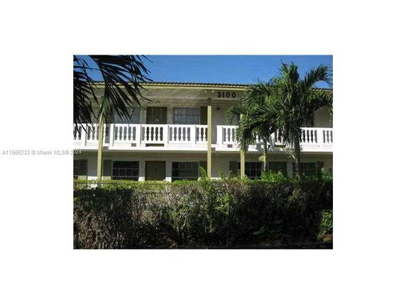 Front view of a two-story building with a balcony and columns.