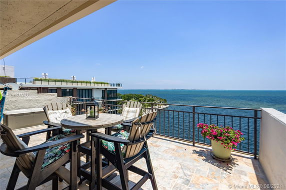 Rooftop terrace with outdoor seating overlooking the ocean.