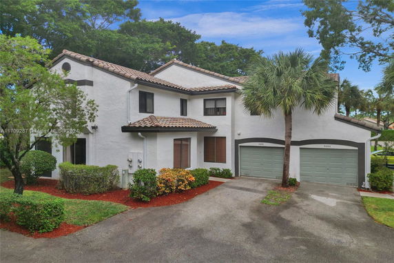 Front view of a two-story house with two garages and a tiled roof.