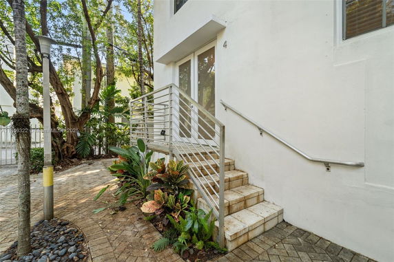 Side entrance of a building with stairs and railing.