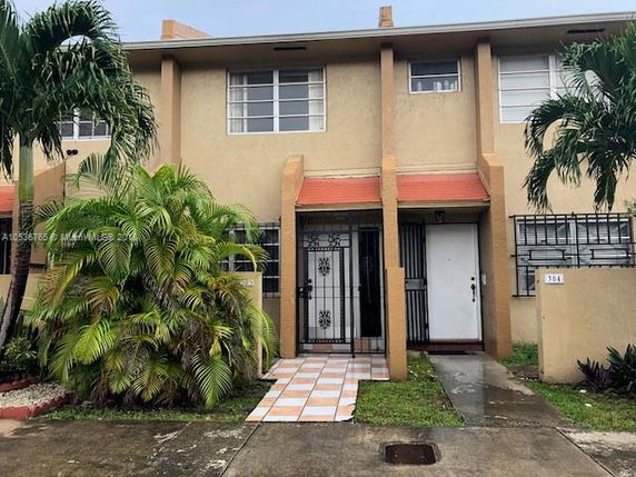 Front view of a two-story townhouse with gated entry.