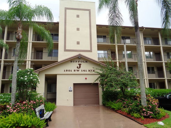Front view of a multi-story apartment building with balconies.