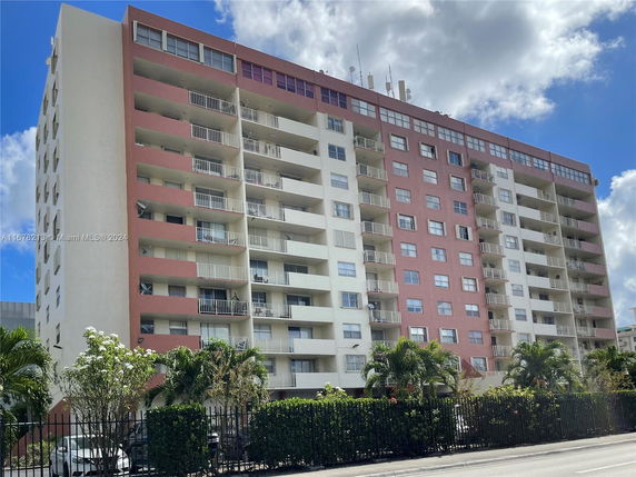 Front view of a multi-story apartment building with balconies.