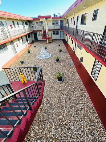 View of building courtyard with gravel and potted plants.