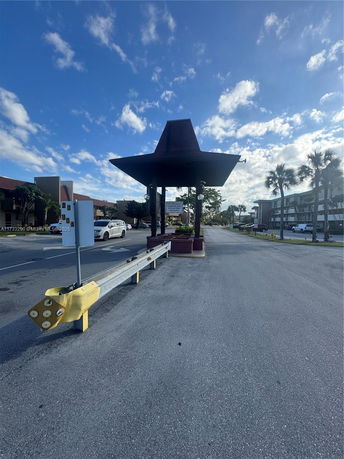 Outdoor parking area with a covered entrance structure.