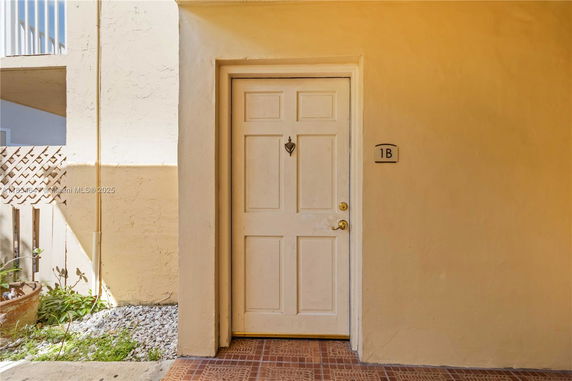 Entrance of a beige-colored building with a door labeled 1B.
