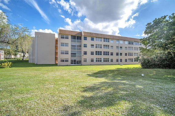 Front view of a multi-story residential building with multiple windows.