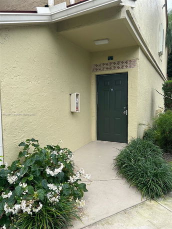 Front view of a house with a covered entrance and green door.