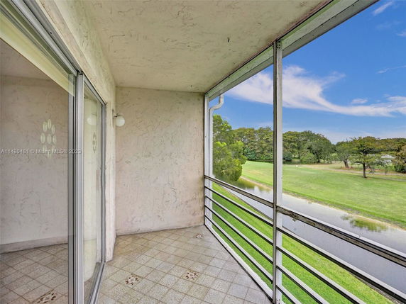 Outdoor balcony with a view of green landscape and water.