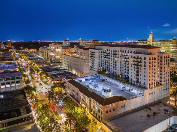 Night view of a city area with well-lit streets and multi-story buildings.