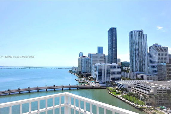 Rooftop view of a city skyline with a bridge and waterfront.