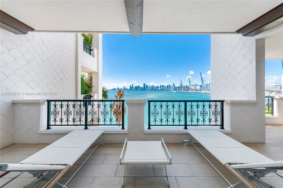 Panoramic view from a balcony showing a coastal skyline and waterfront.