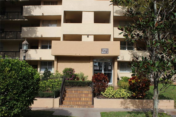 Front view of a multi-story building with balconies and entryway steps.